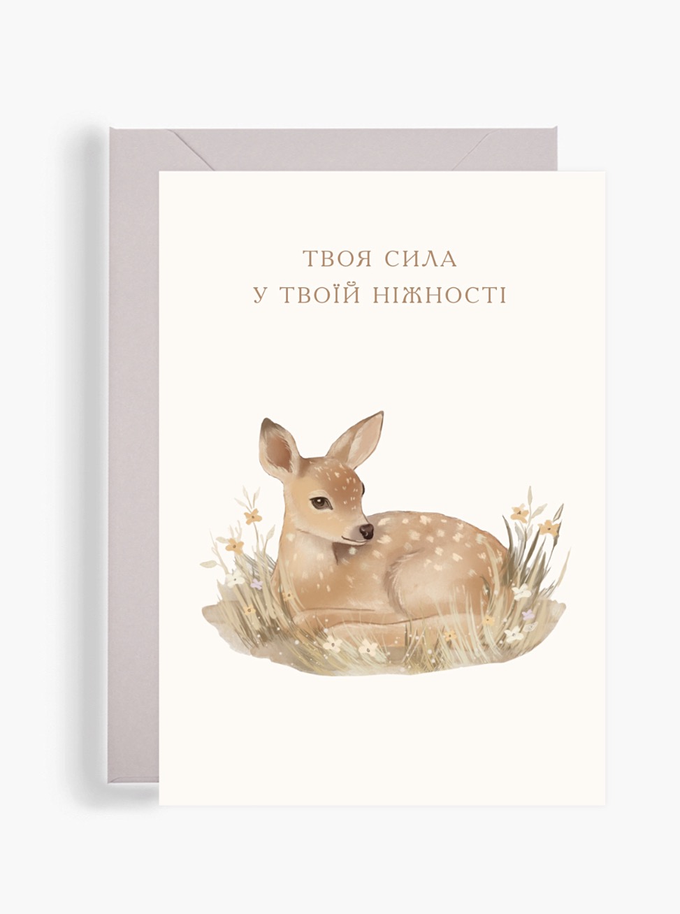 Акварельна поштова листівка Dear Owl із зображенням маленького оленятка серед трави та квітів, поруч із крафтовим конвертом. На листівці надихаючий напис «Твоя сила у твоїй ніжності». Акварельна поштова листівка Dear Owl із зображенням маленького оленятка серед трави та квітів, поруч із крафтовим конвертом. На листівці надихаючий напис «Твоя сила у твоїй ніжності».