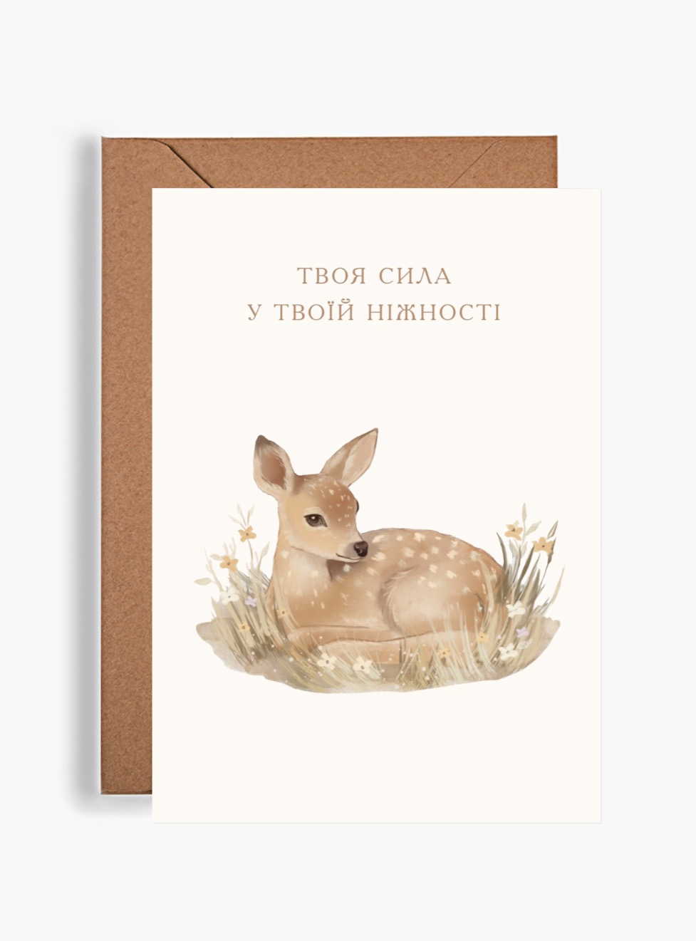Акварельна поштова листівка Dear Owl із зображенням маленького оленятка серед трави та квітів, поруч із крафтовим конвертом. На листівці надихаючий напис «Твоя сила у твоїй ніжності».